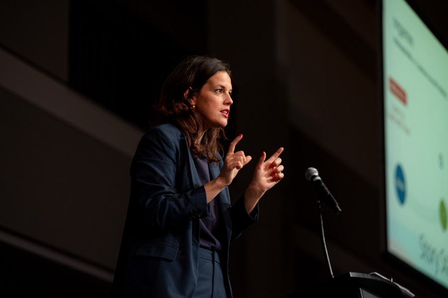 Alison speaking on a dark stage